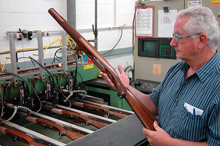At Ruger, an inspector eyes a machine-checkered stock for a Hawkeye rifle. Plain American walnut.